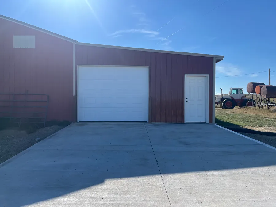 Concrete driveway apron in front of a finished red garage