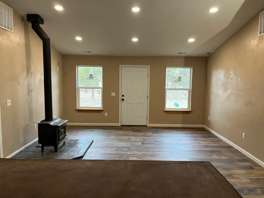 Finished interior of a Hammer Down custom home with wood stove and plank flooring